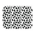 Black and white cow print sherpa blanket laid flat, showing irregular black patches on white with a white sherpa edge
