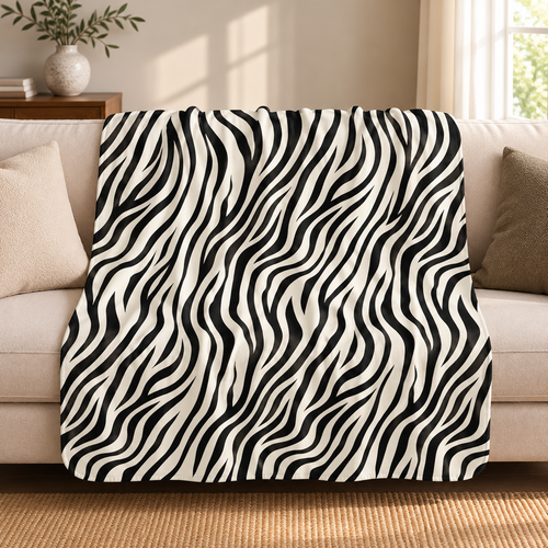 Black and white zebra print sherpa blanket draped over a cream sofa in a living room