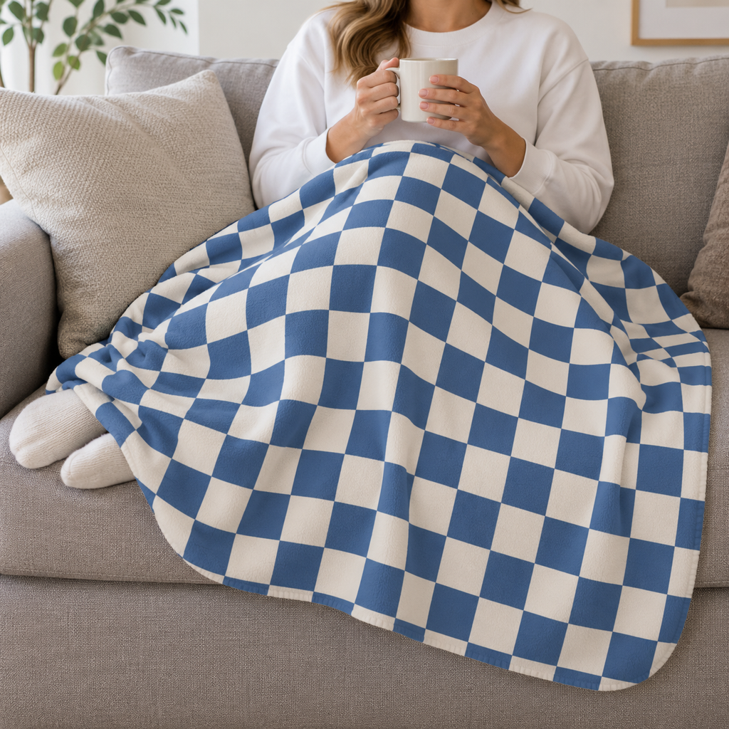 Person relaxing on a couch under the Blue Checkered Sherpa Blanket