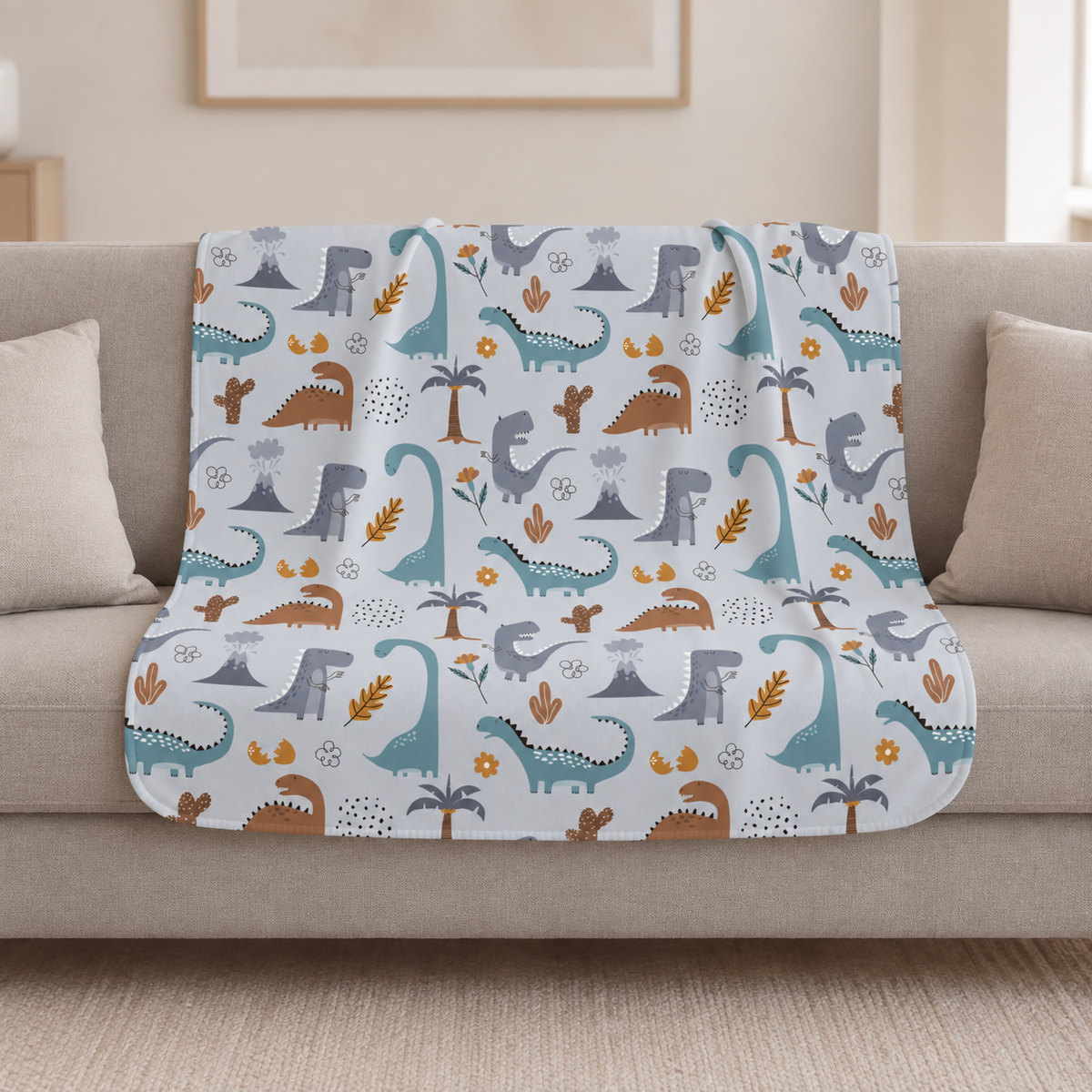 Blue Dinosaur Sherpa Blanket draped over a cream sofa in a living room