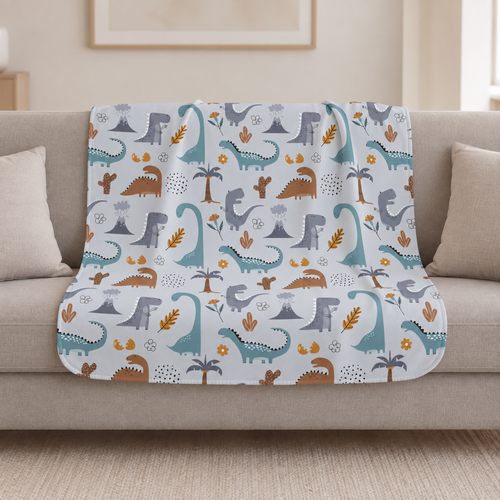 Blue Dinosaur Sherpa Blanket draped over a cream sofa in a living room
