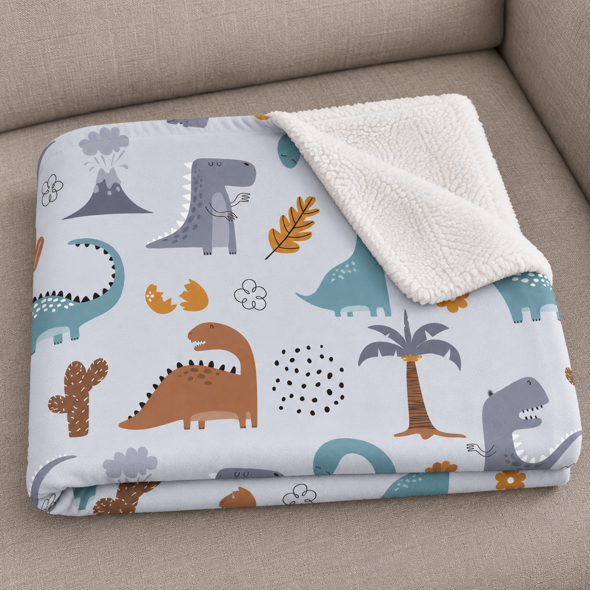 Close-up of the folded Blue Dinosaur Sherpa Blanket showing the sherpa back