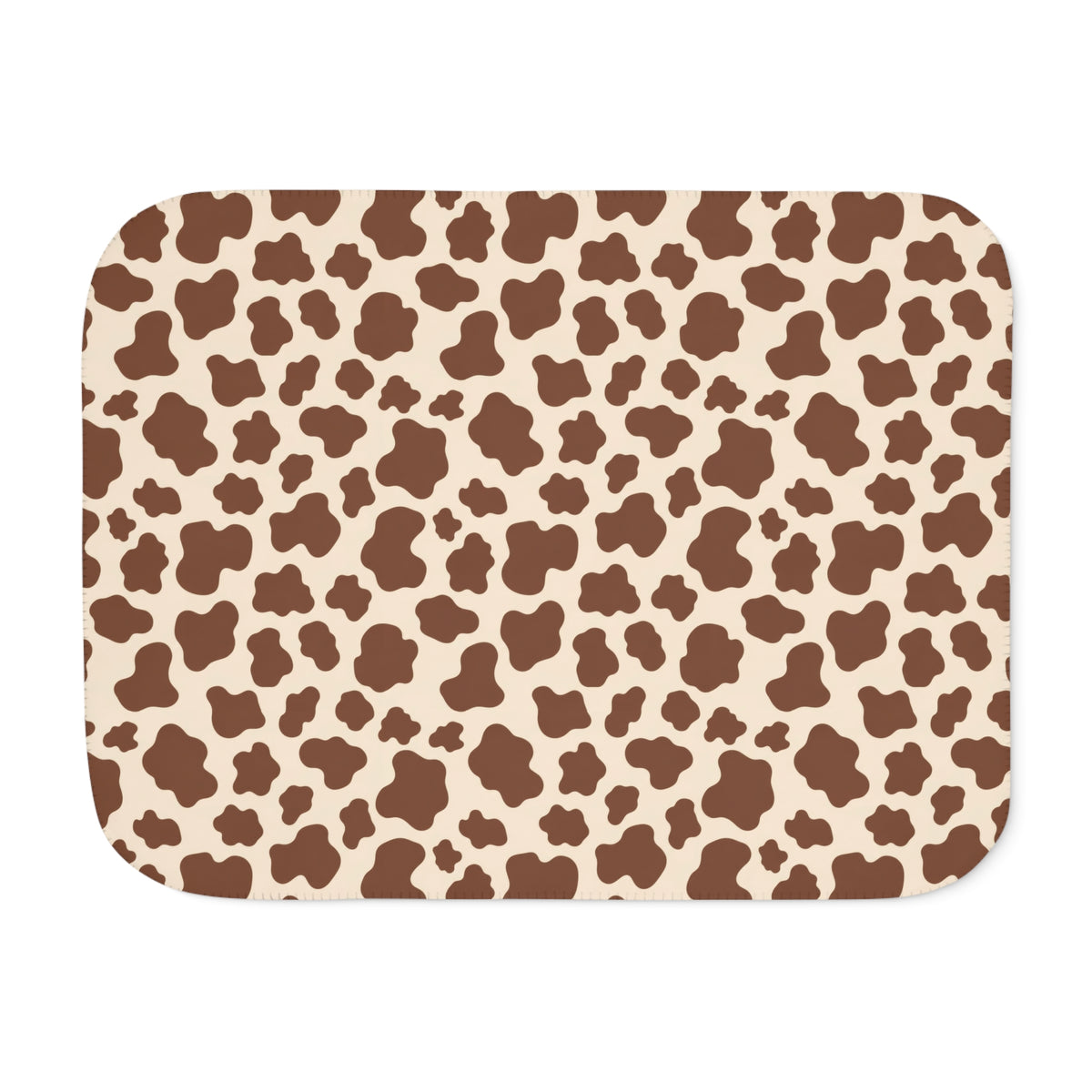Brown cow print sherpa blanket laid flat, showing chocolate brown patches on a cream ground with a white sherpa edge