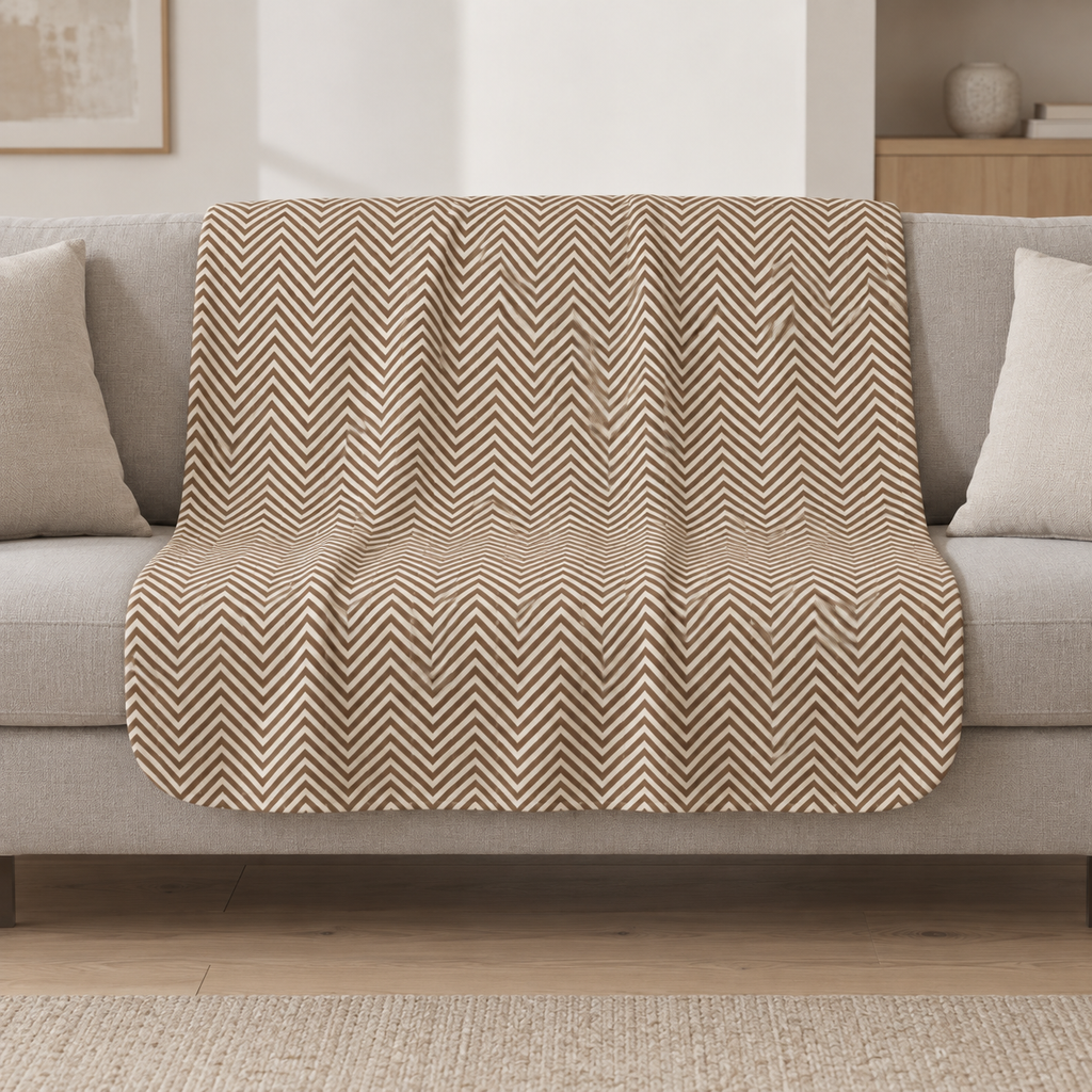 Brown Herringbone Sherpa Blanket draped over a cream sofa in a living room