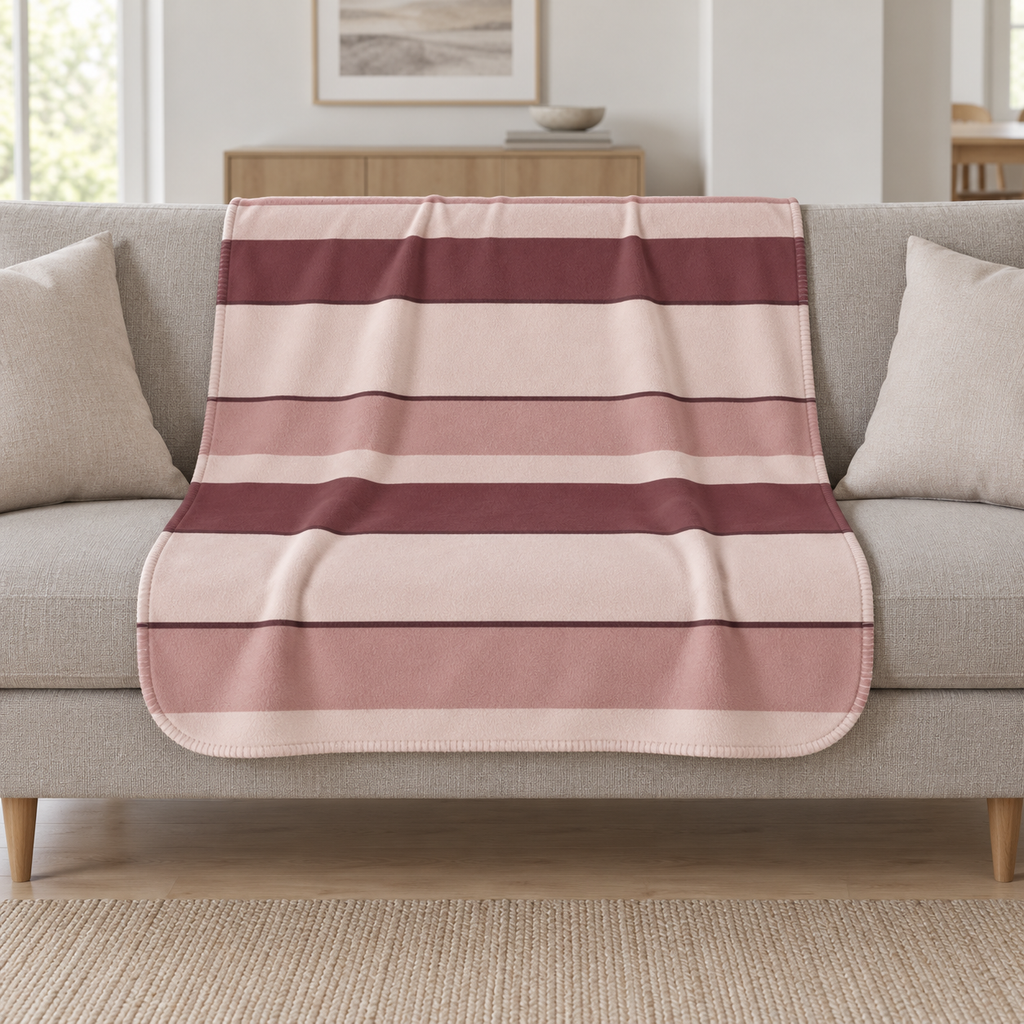 Burgundy Striped Sherpa Blanket draped over a cream sofa in a living room
