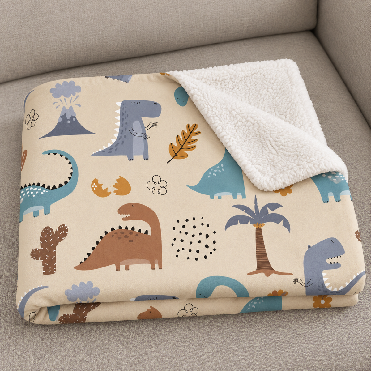 Close-up of the folded Cream Dinosaur Sherpa Blanket showing the sherpa back