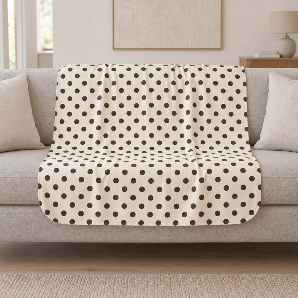 Cream Polka Dot Sherpa Blanket draped over a cream sofa in a living room