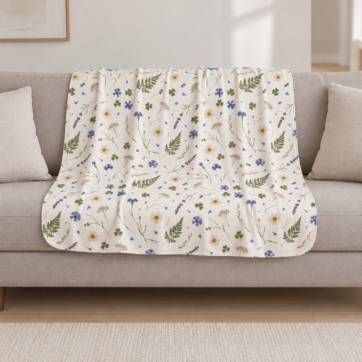 Cream Wildflower Sherpa Blanket draped over a cream sofa in a living room