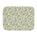 Green cow print sherpa blanket laid flat, showing sage green patches on a cream ground with a white sherpa edge