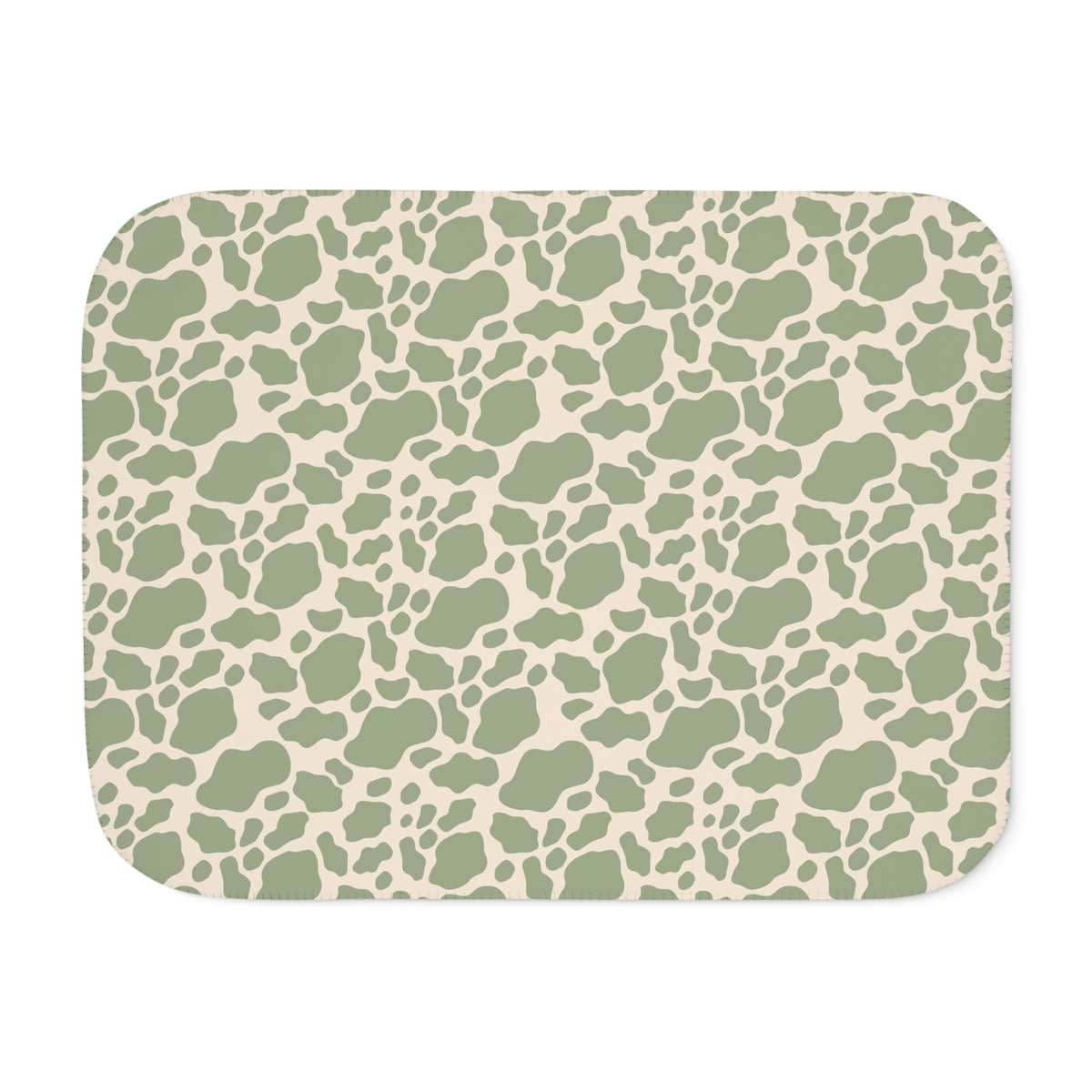 Green cow print sherpa blanket laid flat, showing sage green patches on a cream ground with a white sherpa edge