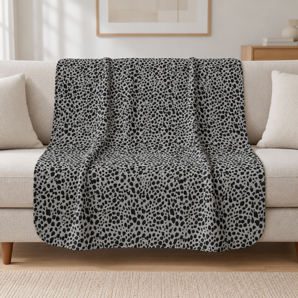 Grey Cheetah Print Sherpa Blanket draped over a cream sofa in a living room