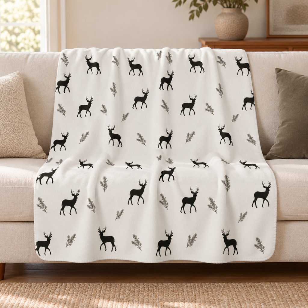 Grey deer print sherpa blanket draped over a cream sofa in a living room