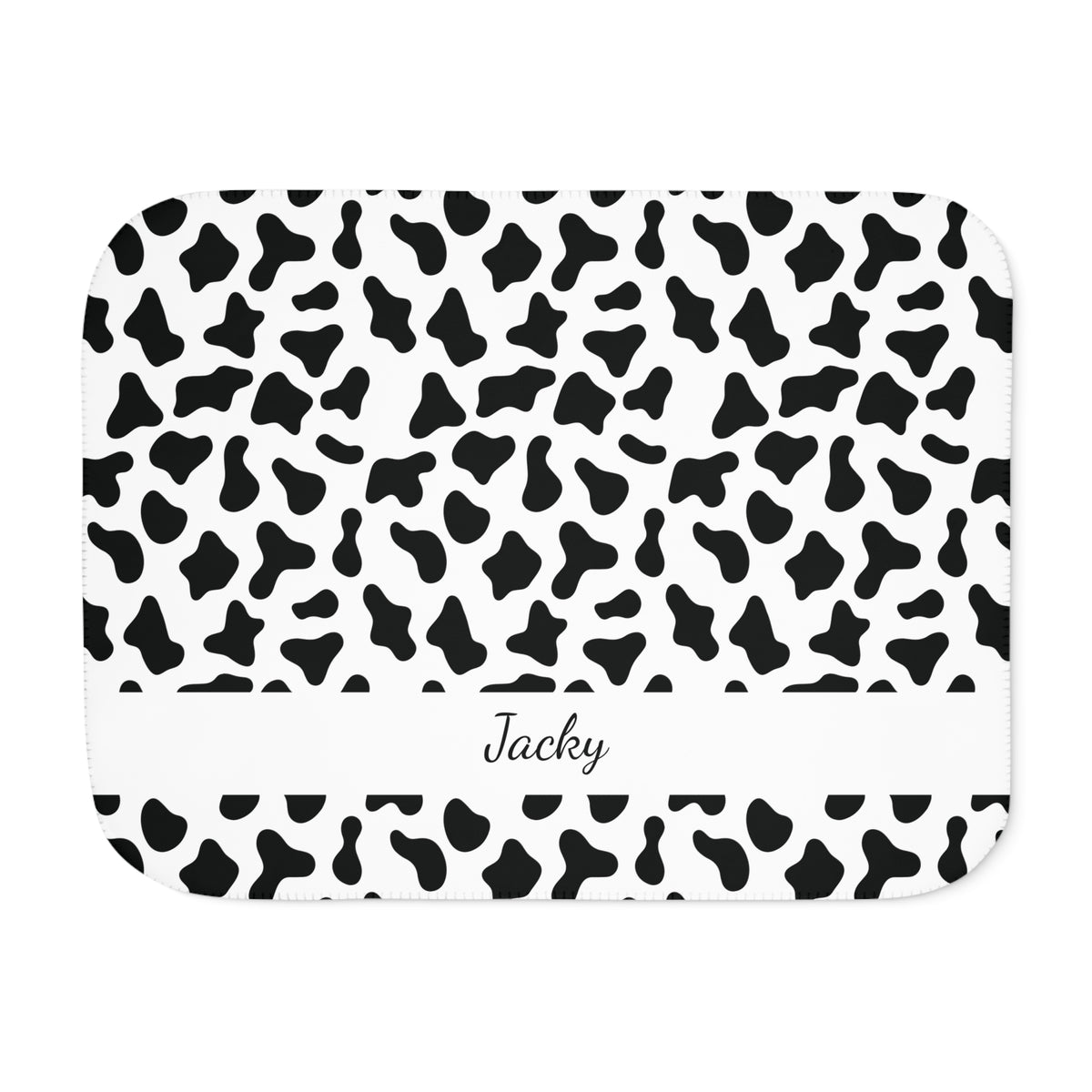 Personalized black and white cow print sherpa blanket with name, front view with name band