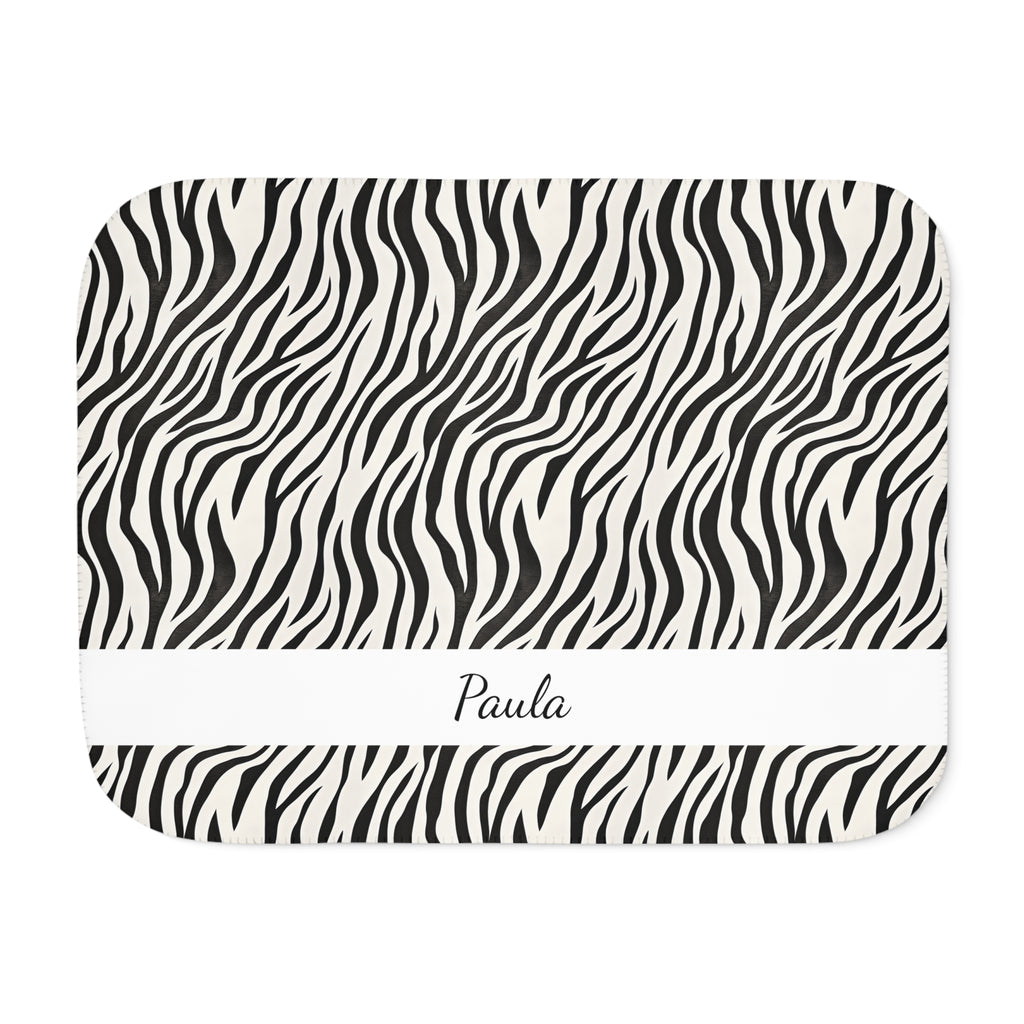 Personalized black and white zebra print sherpa blanket with name, front view with name band