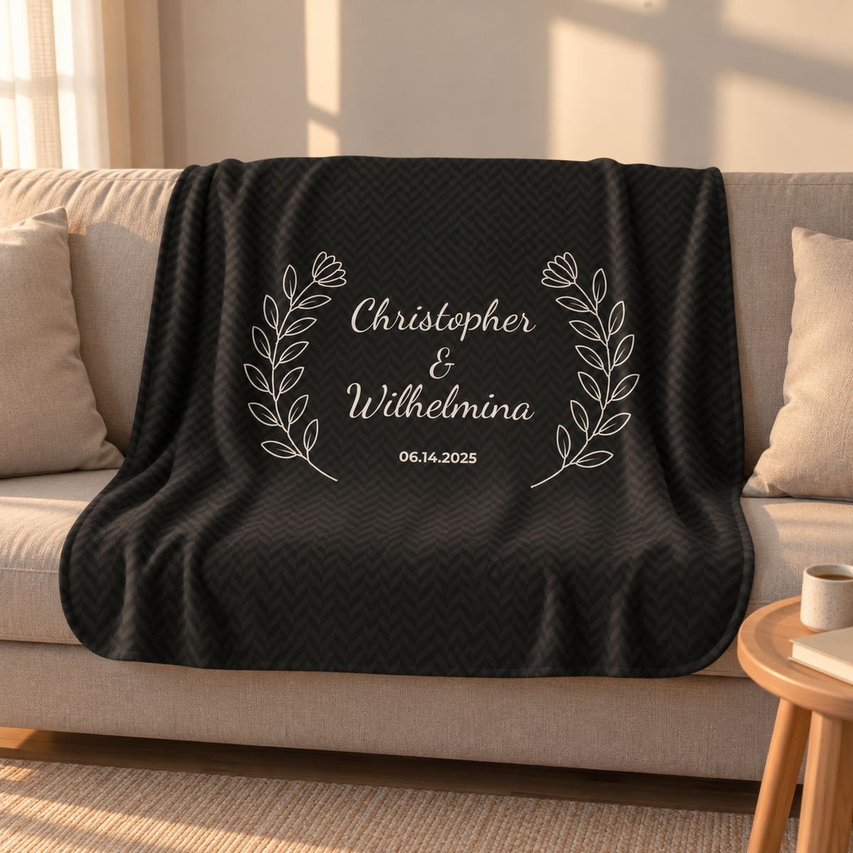 Personalized black sherpa blanket with two names and a date, draped over a couch