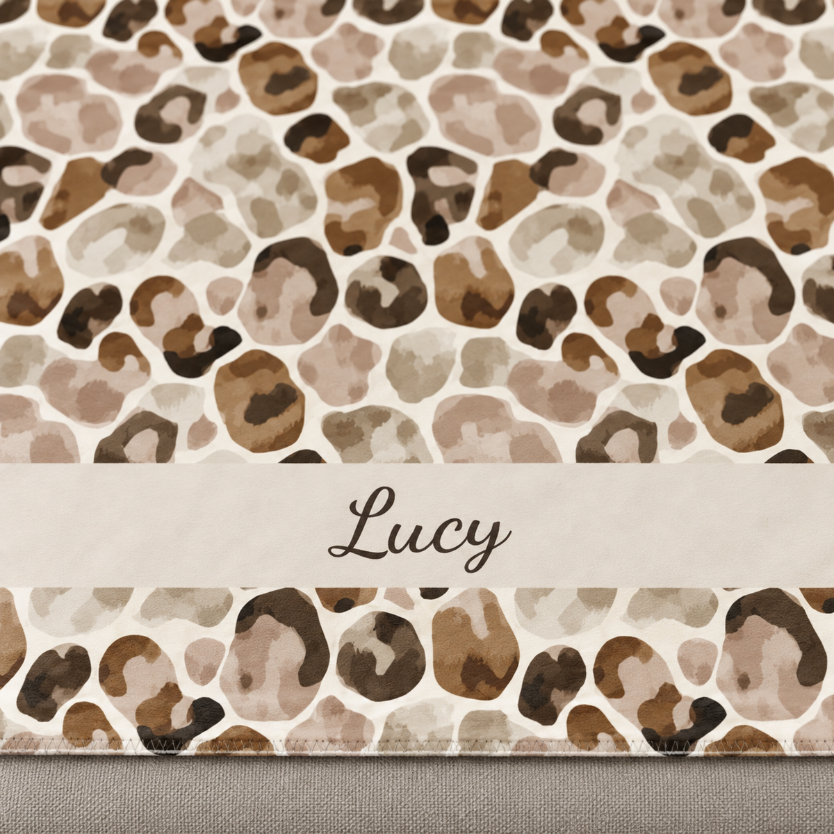 Personalized brown leopard print sherpa blanket with name, close-up of the name in script on the band
