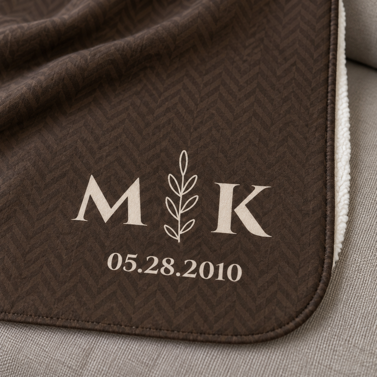 Personalized brown sherpa blanket with monogram, close-up of the monogram on the herringbone weave