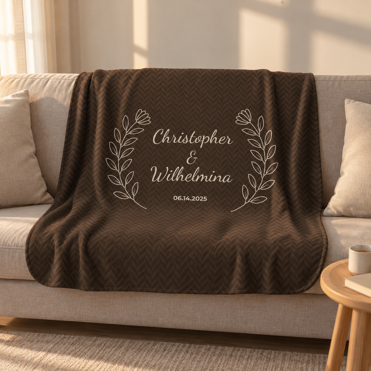 Personalized brown sherpa blanket with two names and a date, draped over a couch