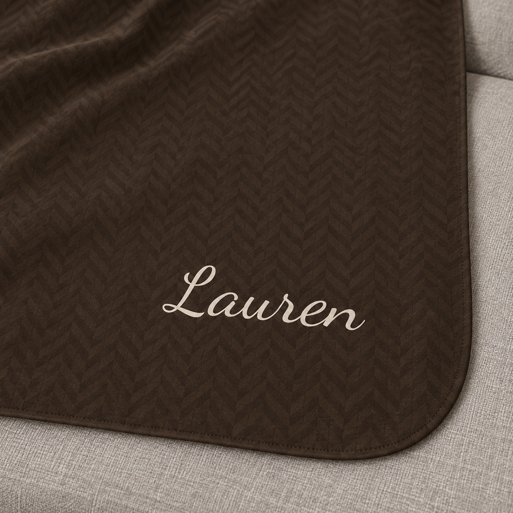 Personalized brown sherpa blanket with name, close-up of the name in script on the herringbone weave