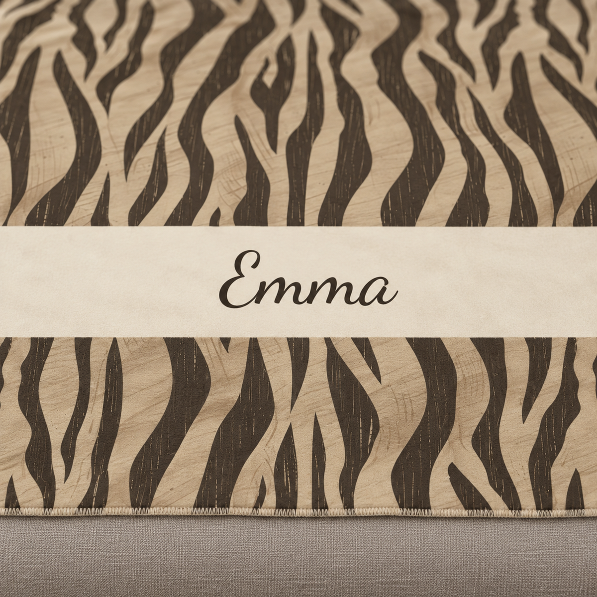 Personalized brown tiger stripe sherpa blanket with name, close-up of the name in script on the band