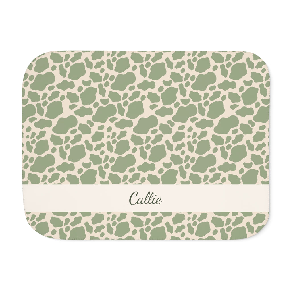 Personalized green cow print sherpa blanket with name, front view with name band