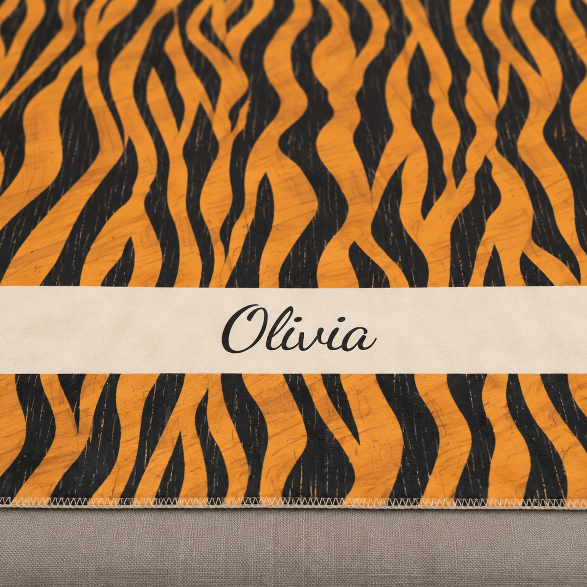Personalized tiger stripe sherpa blanket with name, close-up of the name in script on the band