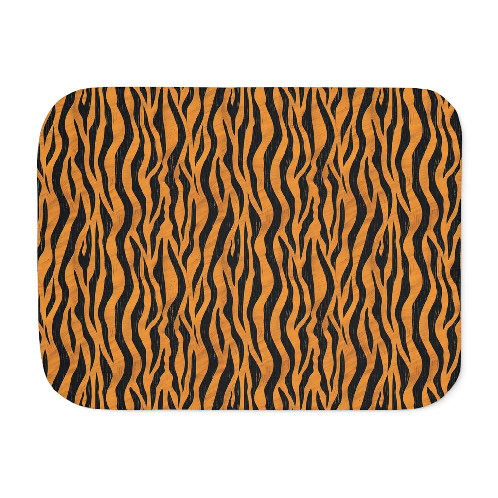 Tiger stripe sherpa blanket laid flat, showing black stripes on a warm orange ground with a white sherpa edge